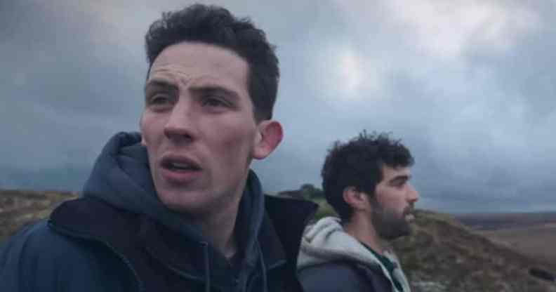 Josh O'Connor looks disgruntled as he looks on against green hills