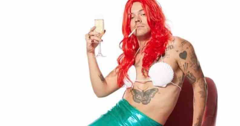 Harry Styles in an Ariel costume, a cigarette in his mouth and holding a flute of champagne