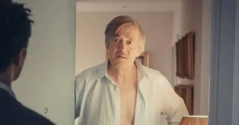 Stephen Fry in It's a Sin, opening the door to someone shirtless