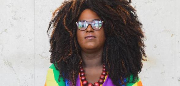 Benny Briolly poses in a rainbow top