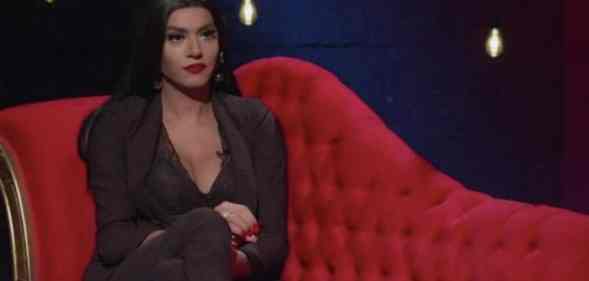 Çağla Akalın sits on a plush red couch