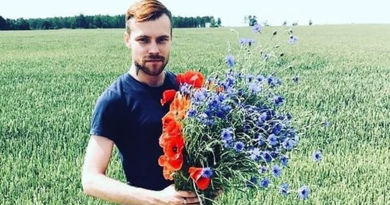Normunds Kindzulis holds a bouquet of flowers in a field