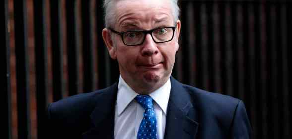 Michael Gove looks confused in a suit and tie standing outside Downing Street