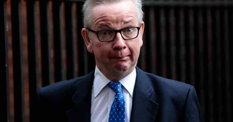 Michael Gove looks confused in a suit and tie standing outside Downing Street