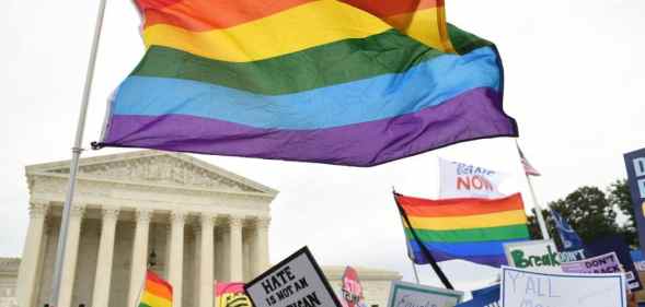 Demonstrators wave LGBT+ Pride flags outside the US Supreme Court