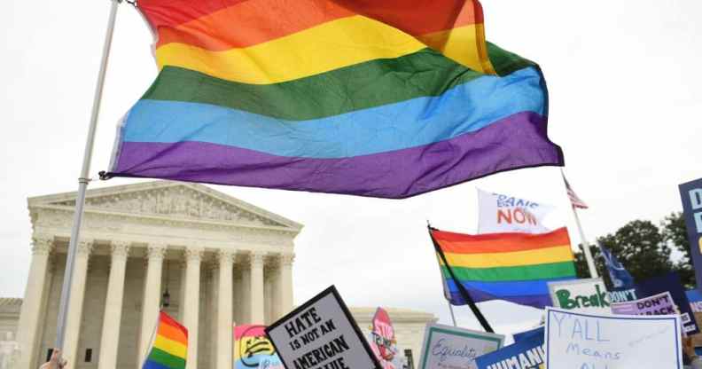 Demonstrators wave LGBT+ Pride flags outside the US Supreme Court