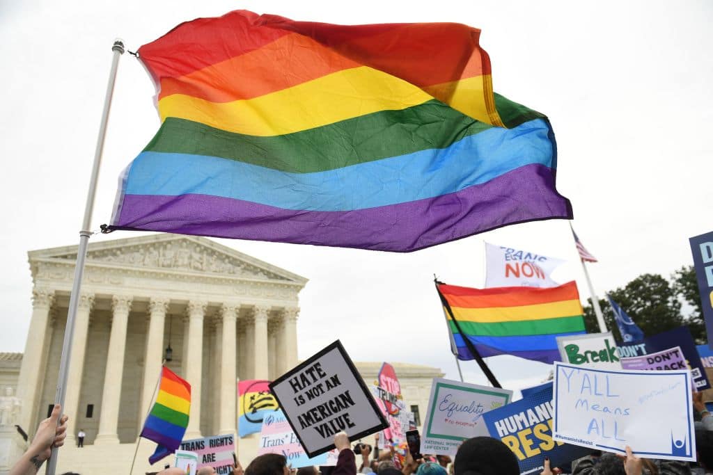 Demonstrators wave LGBT+ Pride flags outside the US Supreme Court
