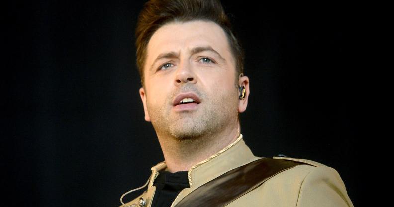 Mark Feehily of Westlife persons on stage in a light brown jacket