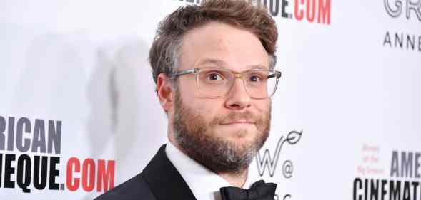 Seth Rogen wearing a tuxedo and a pair of glasses on the red carpet