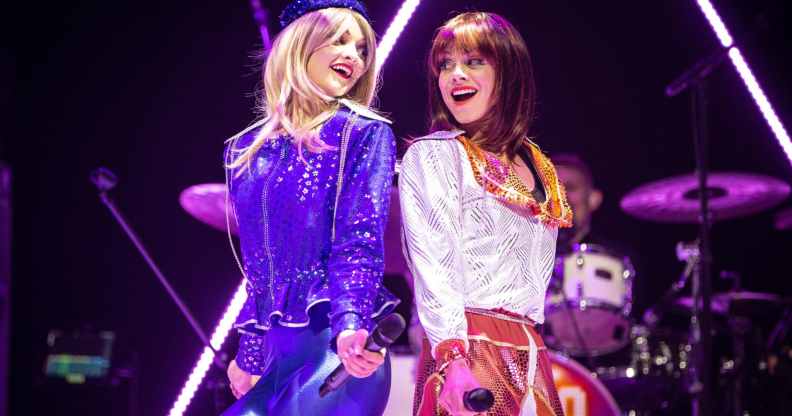 JoJo Desmond and Rhiannon Porter of ABBA MANIA, in costume while singing against one another's backs