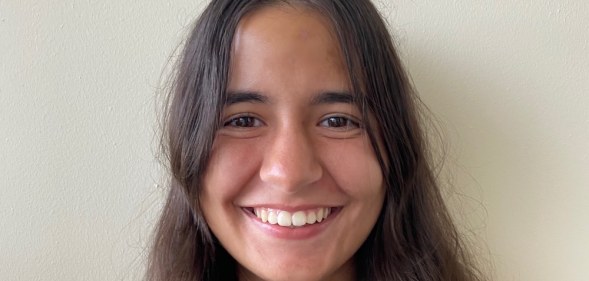 A headshot of Leonor Silva smiling against a grey background