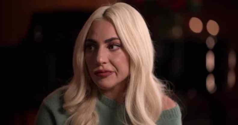 Lady Gaga emotionally looks to the side in a green jumper