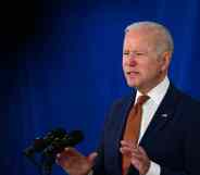 Joe Biden in a suit speaks behind a podium