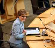 Nicola Sturgeon sits down in Holyrood in a blue pant suit