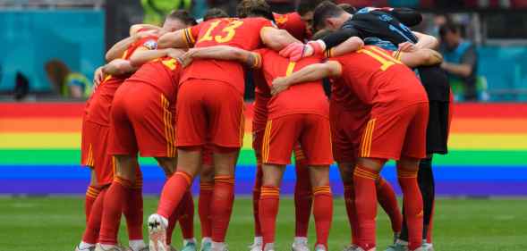 Denmark players form a circle in front of a rainbow advert during the UEFA Euro 2020 Championship Round of 16 match between Wales and Denmark
