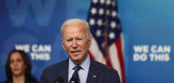 President Joe Biden (R) speaks as vice president Kamala Harris (L) listens