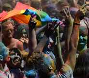 A woman brandishes a Rainbow flag during a Holi Party before the Gay Pride Parade in Barcelona