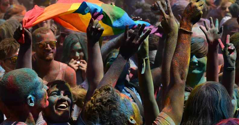A woman brandishes a Rainbow flag during a Holi Party before the Gay Pride Parade in Barcelona