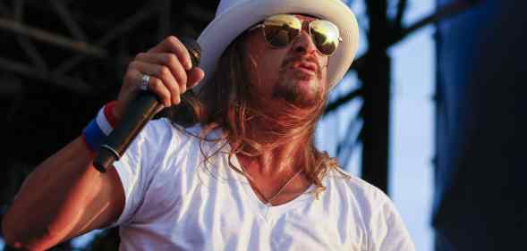 Kid Rock performs in a white v-neck and white fedora