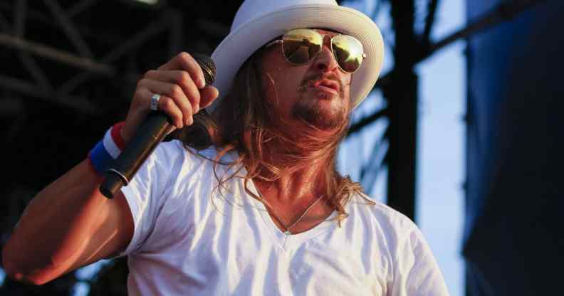 Kid Rock performs in a white v-neck and white fedora