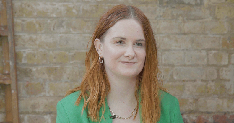 Chloe, sat in front of a brick wall