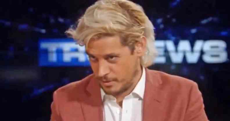Milo Yiannopoulos looks down while wearing a shirt and blazer