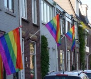 A row of homes adorned with the LGBT+ Pride flag