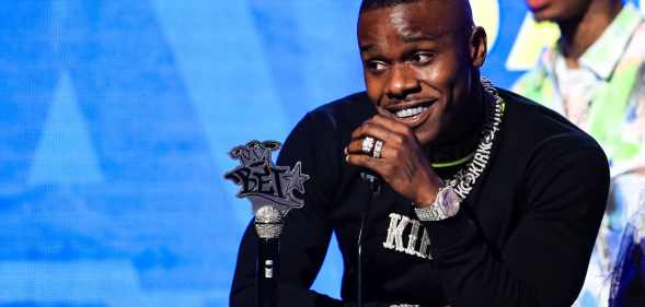 DaBaby speaks in a black sweatshirt onstage at the BET Hip Hop Awards 2019