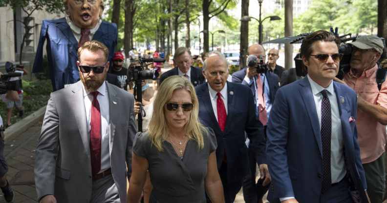 Protestors hold an effigy of former President Donald Trump as Marjorie Taylor Greene, Louie Gohmert and Matt Gaetz arrive for a news conference