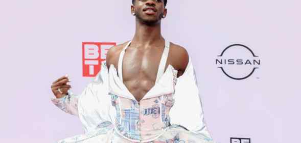 Lil Nas X poses for a photograph at the BET Awards in a flowing dress