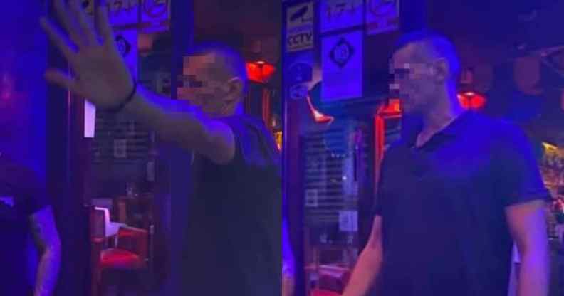 A bouncer tries to stop his photograph being taken at a dimly-lit bar