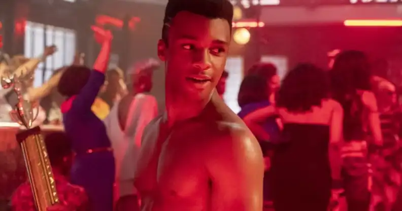 Dyllón Burnside as Ricky in Pose, topless, holding a trophy