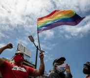 A person flies an LGBT+ Pride flag in Venezuela