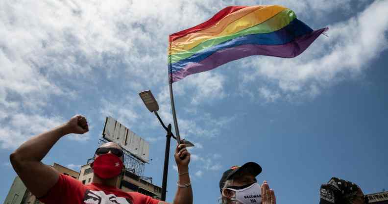 A person flies an LGBT+ Pride flag in Venezuela