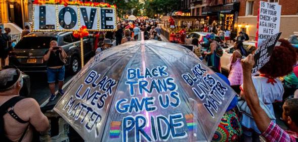A participant seen holding an umbrella turned into a LGBT+ rights and BLM sign