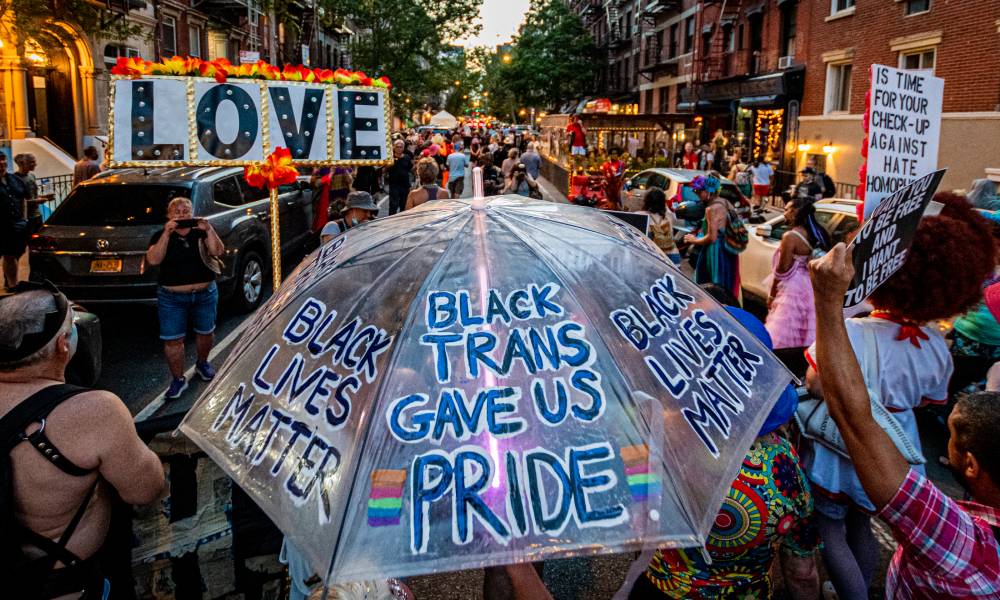 A participant seen holding an umbrella turned into a LGBT+ rights and BLM sign