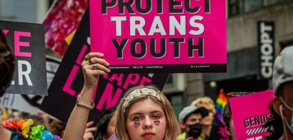 Person holding up 'Protect Trans Youth' sign
