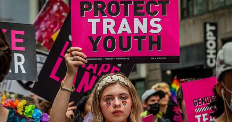 Person holding up 'Protect Trans Youth' sign