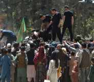 Internally displaced Afghan people, who fled from the northern province due to battle between Taliban and Afghan security forces, gather to receive free food being distributed by Shiite men at Shahr-e-Naw Park in Kabul on August 13, 2021.
