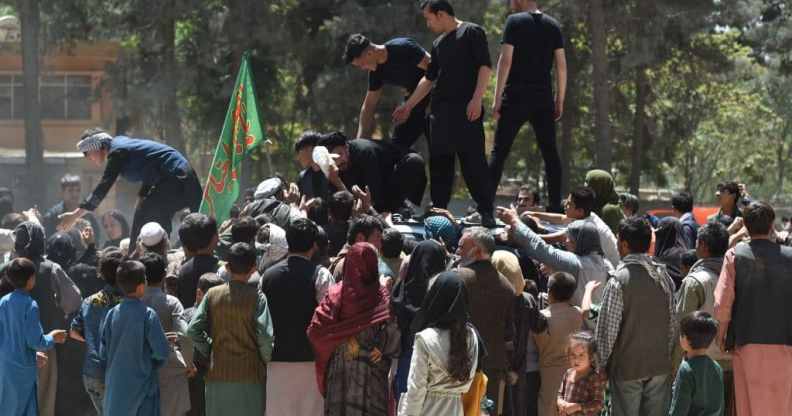 Internally displaced Afghan people, who fled from the northern province due to battle between Taliban and Afghan security forces, gather to receive free food being distributed by Shiite men at Shahr-e-Naw Park in Kabul on August 13, 2021.