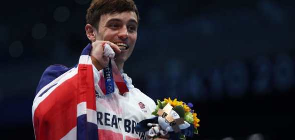 Tom Daley posing with his gold medal