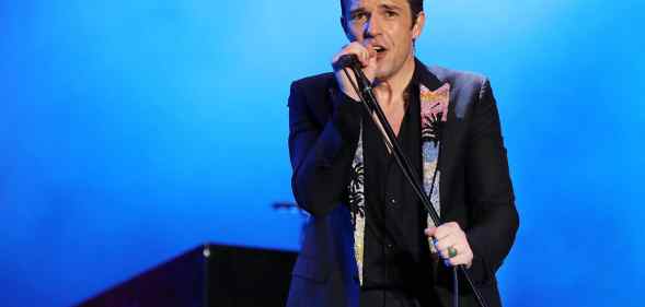 Brandon Flowers of The Killers performs in a black blazer