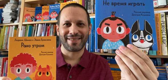 Lawrence Schimel holds Russian translations of children's books 'Early One Morning' and 'Bedtime, Not Playtime!'
