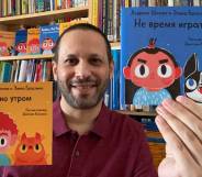 Lawrence Schimel holds Russian translations of children's books 'Early One Morning' and 'Bedtime, Not Playtime!'