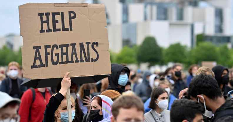 A participant holds up a placard reading 'Help Afghans' during a demonstration