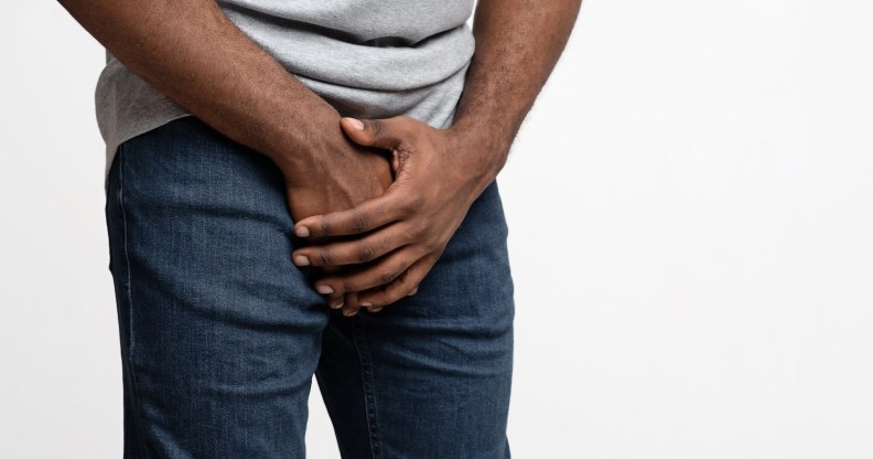 Man holding his hands over his penis