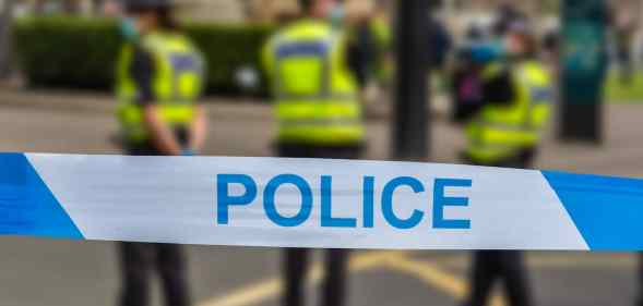 Police officers stand behind a police line