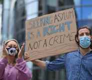 Protesters outside the Home Office holding a sign that reads: Seeking asylum is a right not a crime