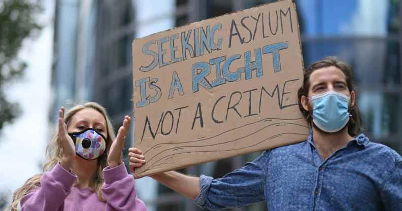 Protesters outside the Home Office holding a sign that reads: Seeking asylum is a right not a crime
