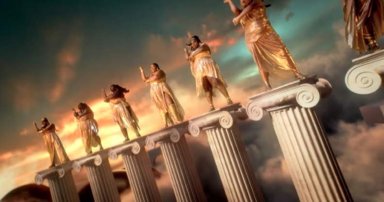 Lizzo and dancers standing atop Greek columns